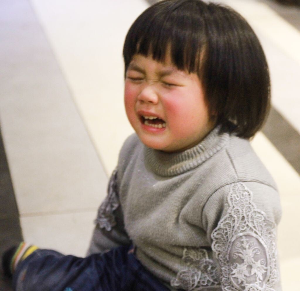 坐在地上撒娇的小女孩