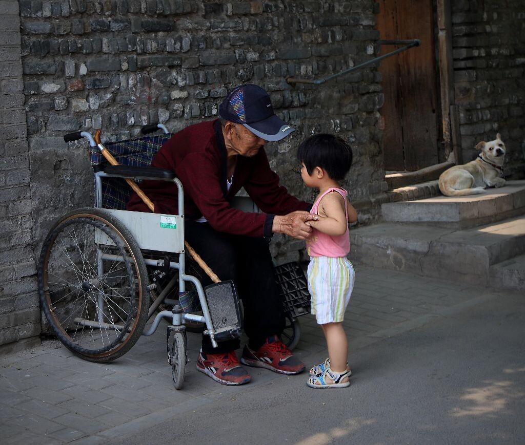 胡同中，老人、小孩还有那只狗。
