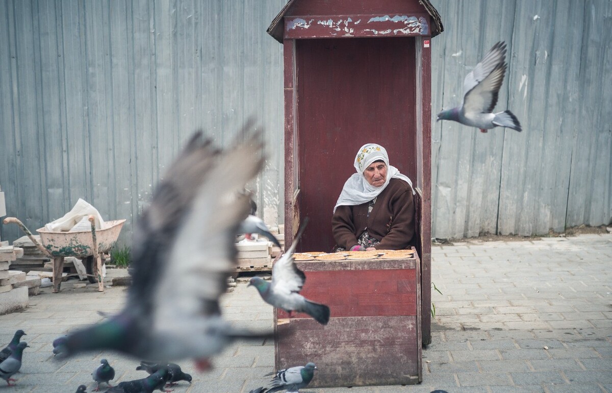 耶尼清真寺门口广场卖鸽子食的老奶奶，然而她只是一排小亭子中的一个。
