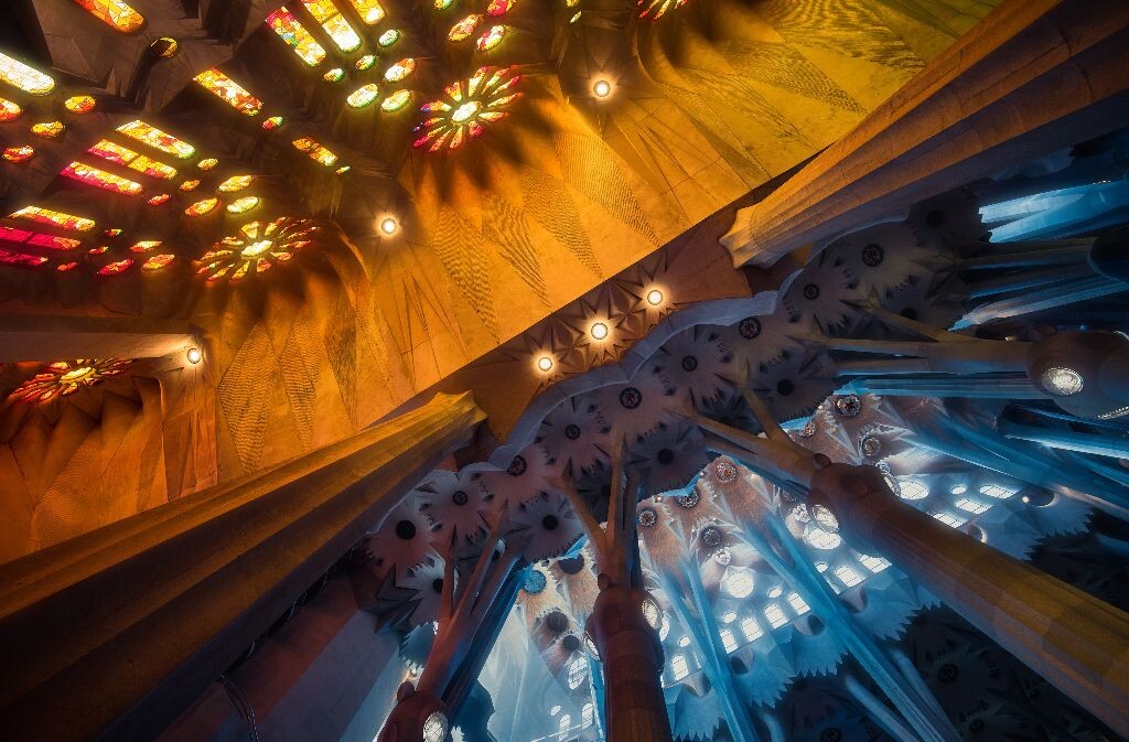 圣家堂的内部侧廊。受光面加暖色彩色玻璃，跟内部的阴影面和冷色彩色玻璃形成鲜明对比。