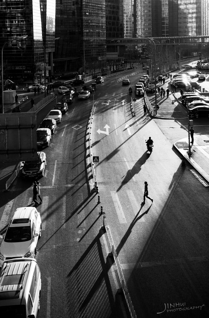 日落前的阳光，温暖而有质感，把行人的影子投射在悠长的街道上。一副下班回家的感觉。2016.3北京中关村