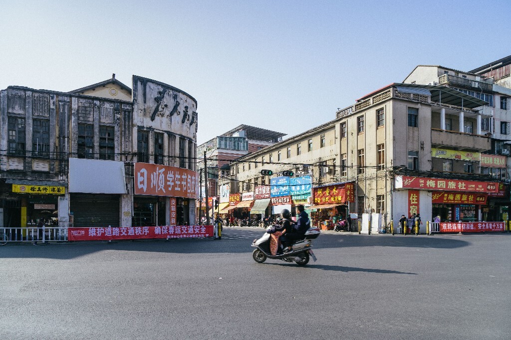 梅城五洲城客运站路口的房子,上面还有为人民服务的旧字呢。