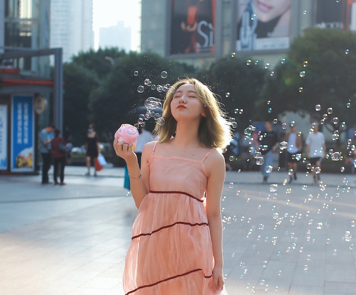 街拍玩泡泡机的小美女