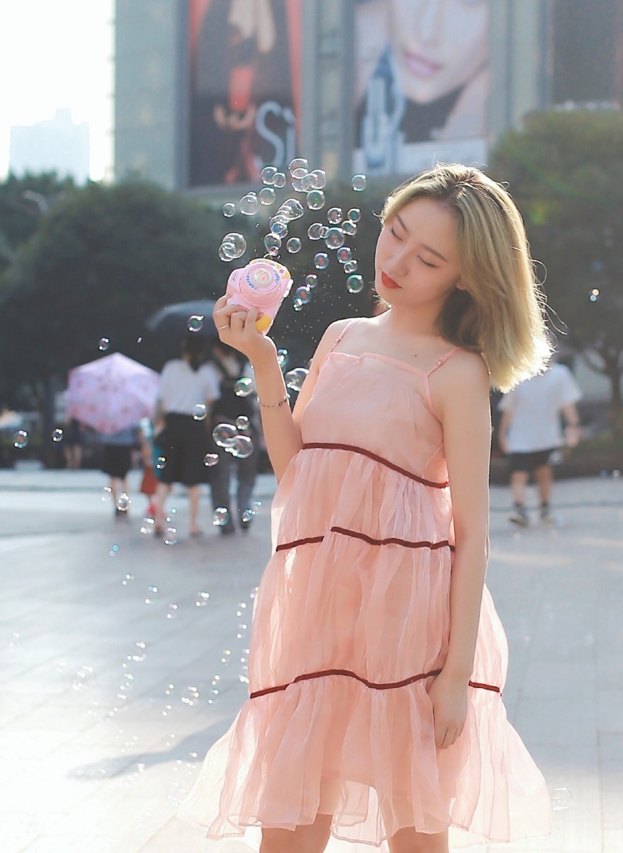 街拍玩泡泡机的小美女