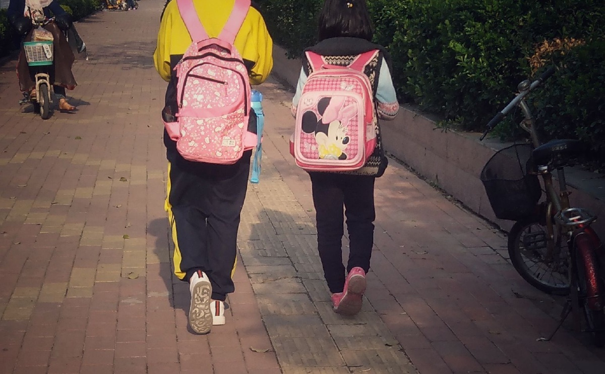 小学生背着书包回家与购物满满的路人