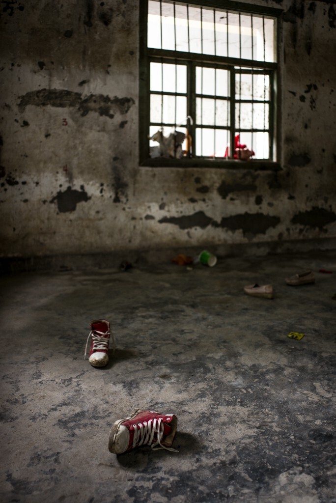 一户废弃的房屋；一双红色的运动鞋也被丢弃其中，显得有那么一丝扎眼。