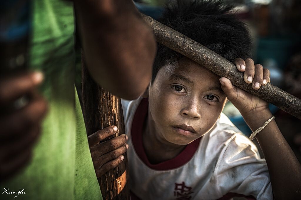 高棉的凝望<br />
当我们在洞里萨湖畔的小村落和孩子们玩耍时，这个小男孩独自一人躲在一旁，用近乎渴望的眼神望着其他的孩子，虽然不知道在他的背后究竟有怎样的故事，但是这样的眼神让人颤动