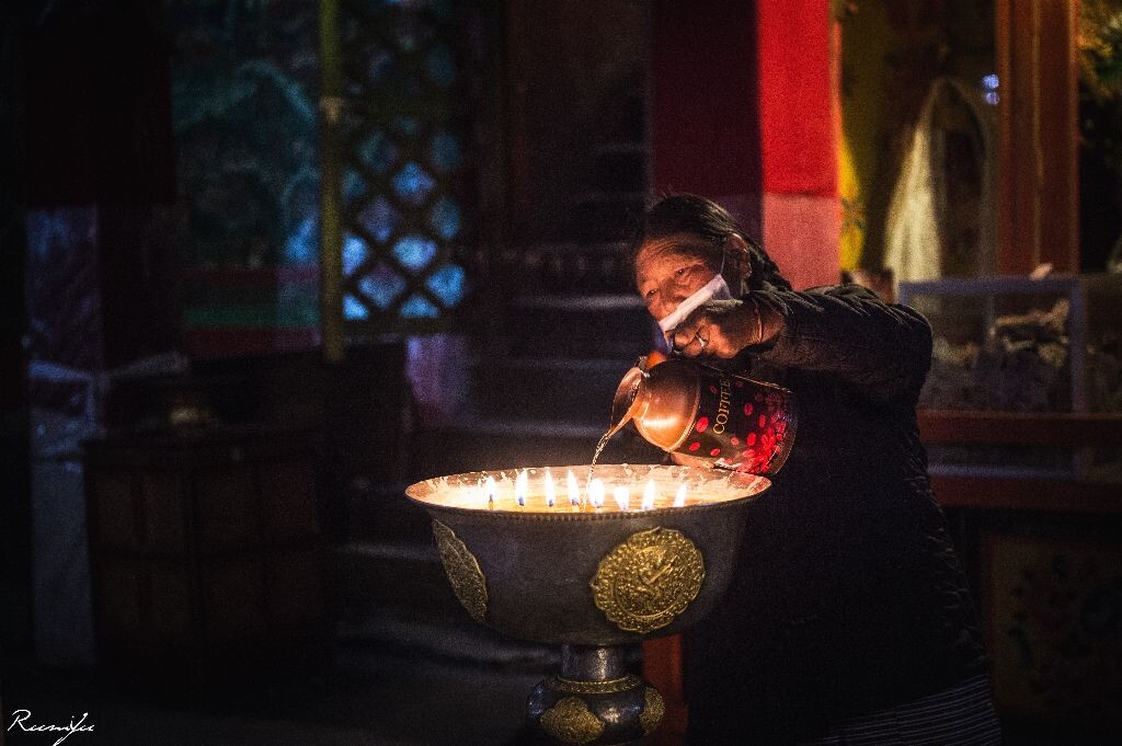 加灯油<br />
哲蚌寺大殿中为酥油灯加油的老妇人