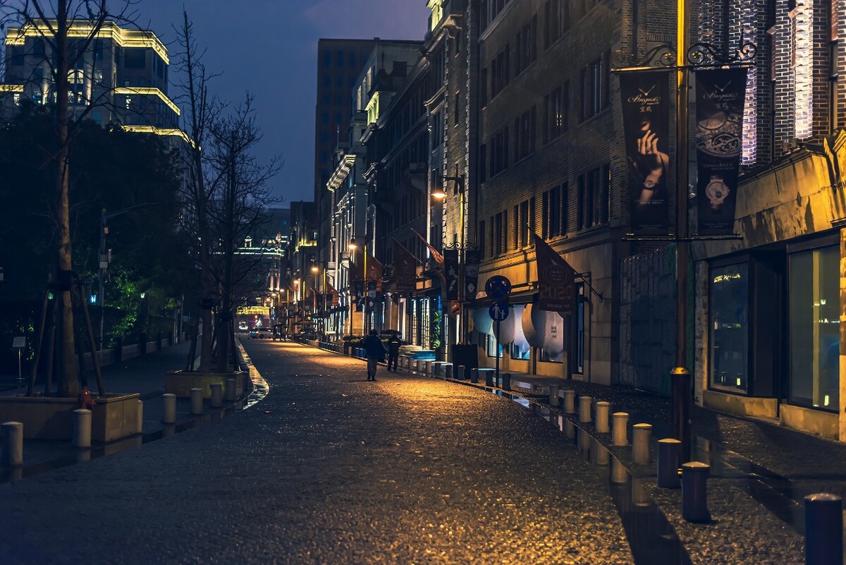 雨中的圆明园路灯光依旧，但失去了平日的活力。