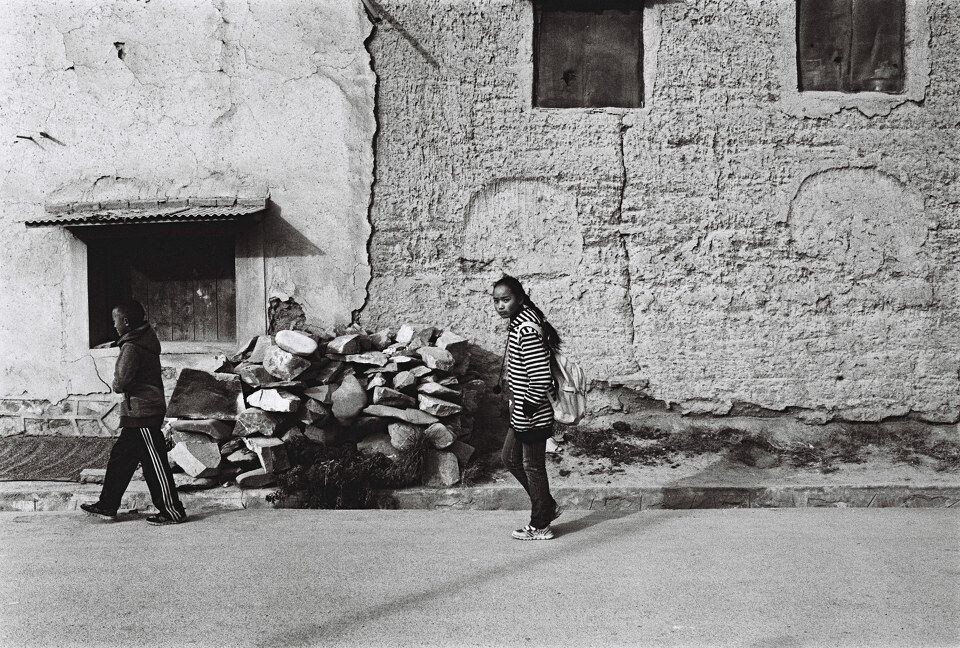 Girl passing by with a squint. Xiahe, Gansu<br />