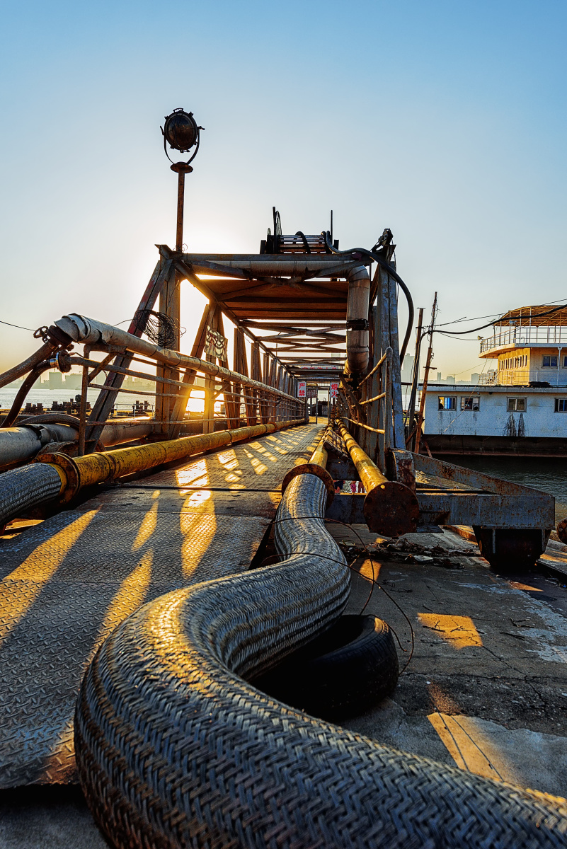 夕阳照射下的长江渡口,油气管道像一条蠕动的蟒蛇.