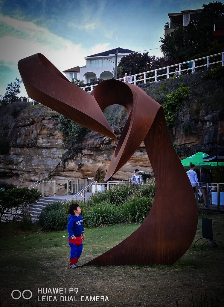 未来战士<br />
拍摄时间: 06/11/2016<br />
拍摄地点 :Sydney Bondi<br />
Syndey Bondi海边每年都会举办国际雕塑展,吸引来自世界各地的艺术家参与。这小男孩有趣的着装和凝望神态让人想起未来战士景像。华为P9记录下。