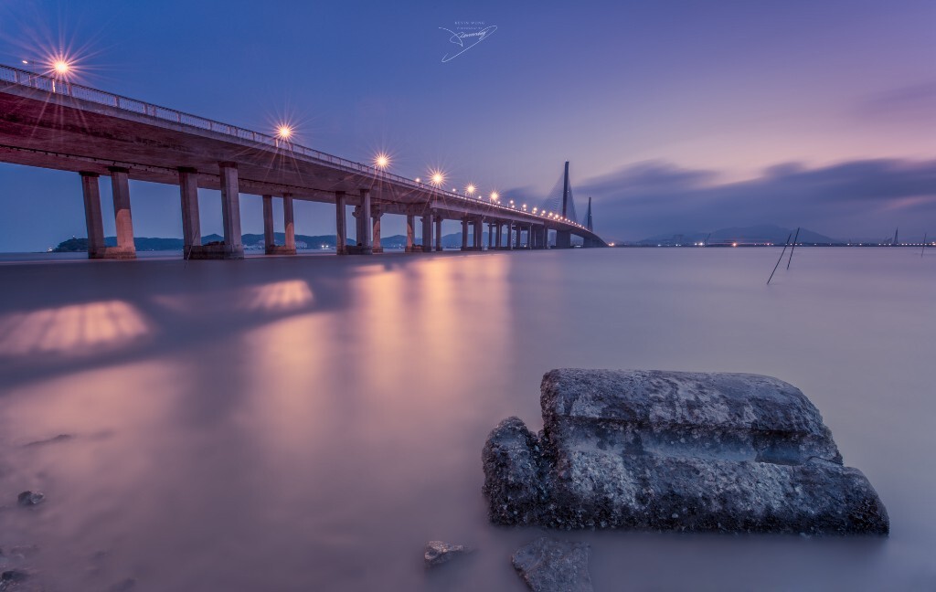 黄昏时分的珠海淇澳大桥，一块石头安静地作着前景，长曝的海水给人宁静的感觉。