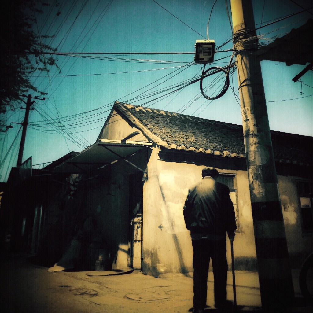 2015年11月26日,江苏省盐城市<东闸村>---最大城中村,摄于iphone6 plus<br />
这是在一片热闹商户旁的小巷子里,一位老者正步履蹒跚踱步回家。