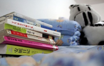 12.【拍摄你的床】我的床上除了被子和枕头外还有两样重要的东西：一是我最爱的书，二是一个像猪又像牛的娃娃。每天看着我的书，抱着