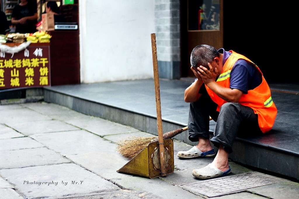 老街偶遇一位坐路边打盹的清洁工大爷。屯溪老街是黄山市非常有名的景点，每天人络绎不绝，要一直保持地面清洁工作量很大。请大家爱护景区环境，文明参观。