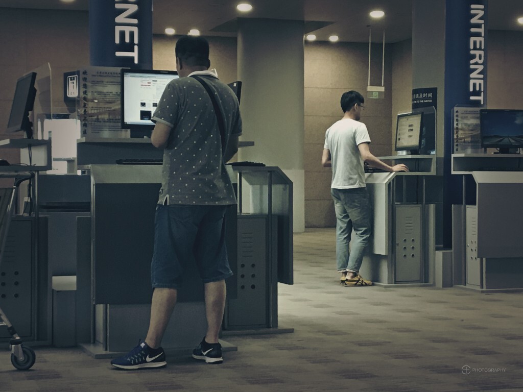 上海浦东机场,打发时光的上网者。