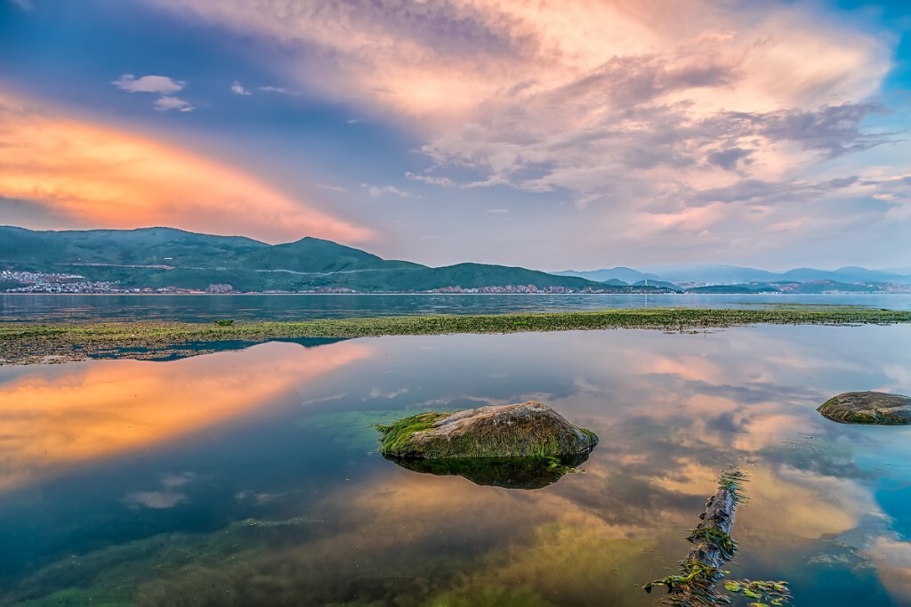 大理洱海，背后的夕阳将东边的云彩映照地金黄。<br />
水中的倒影和石头上的水藻都这么美。
