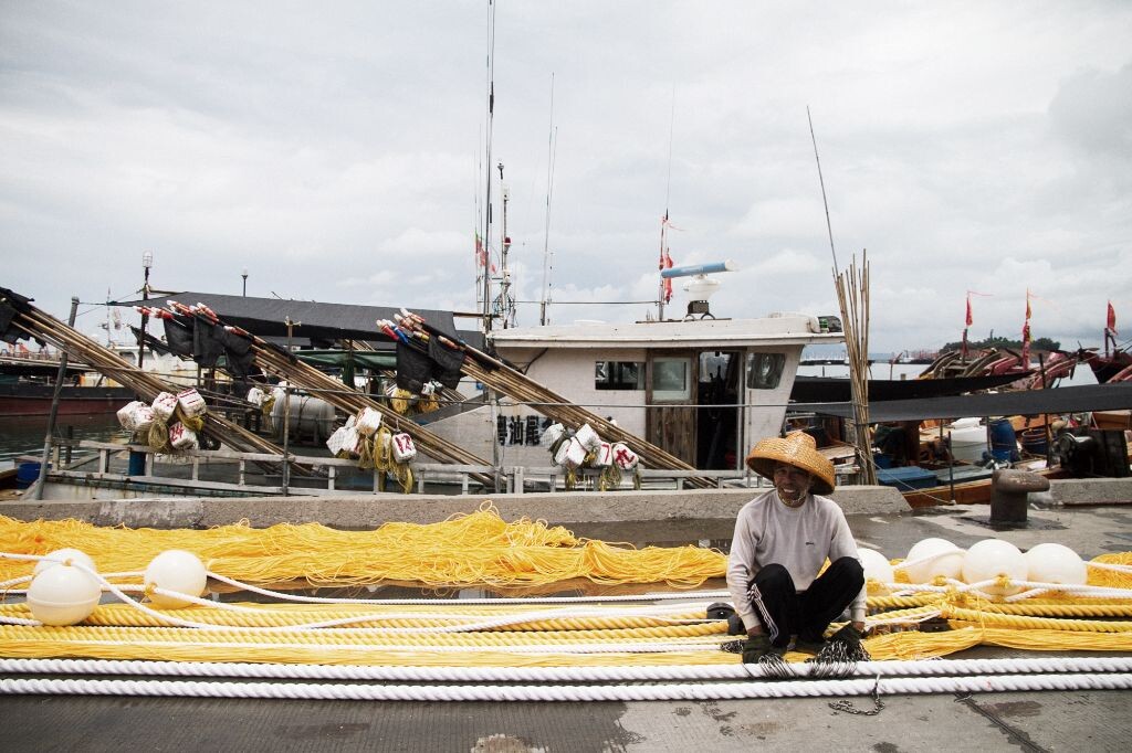 图为渔民在修整渔网。<br />

