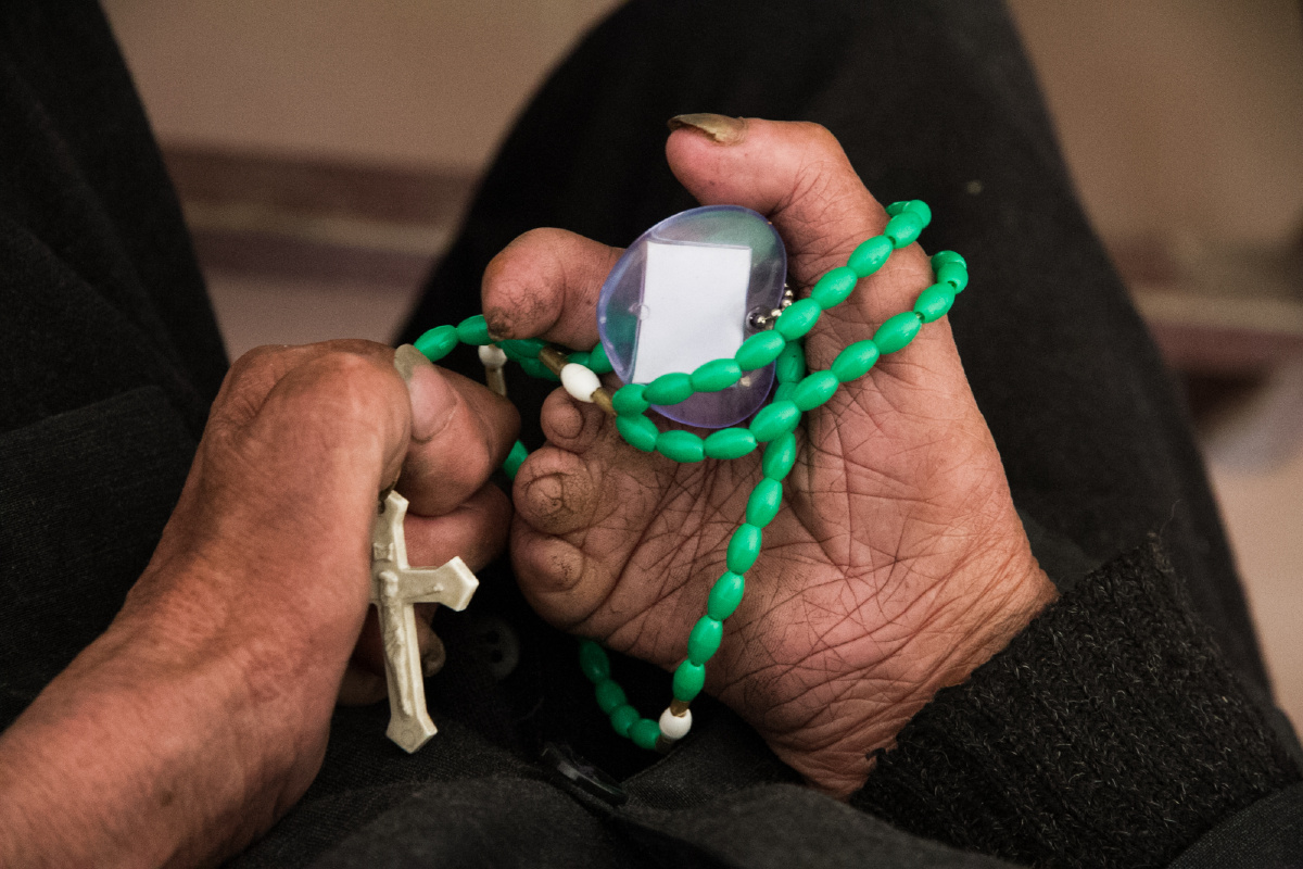 医院的教堂里,一位康复者手中拿着十字祈祷,整个村里有16名天主信徒.