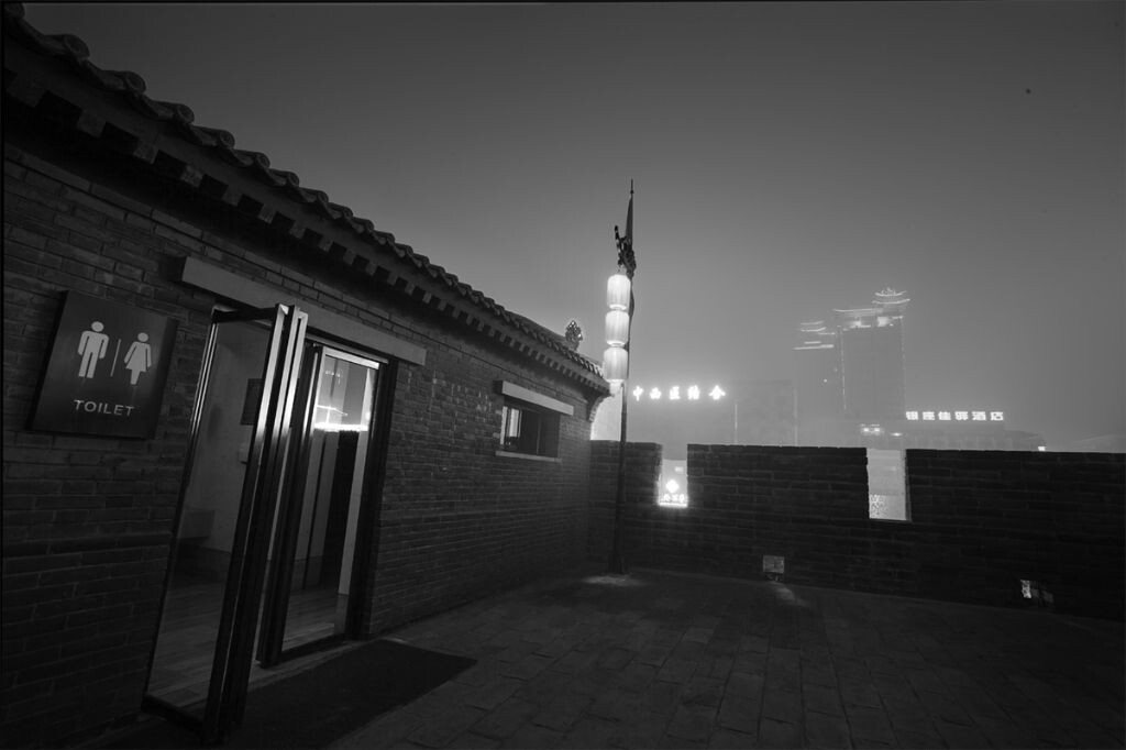 从城楼上的公厕处可以看到远处医院的楼牌上写着：中西医结合。