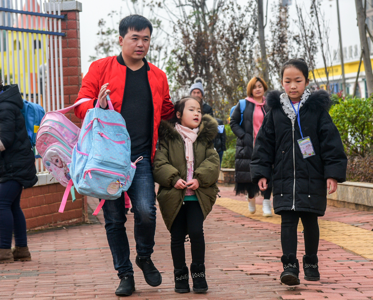 2018年12月13日拍于祁阳县明德小学,母亲牵着两个孩子放学回家.