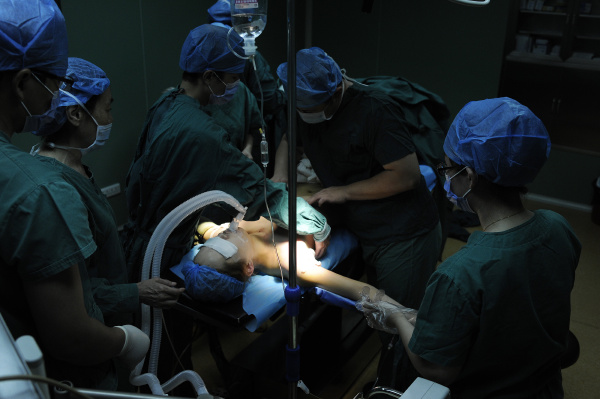 手术过程中,医生将一块硅胶塞进小娇的胸部.