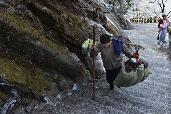 6旬挑山工担140斤,爬8小时山路赚84元