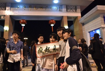 一个女孩抱着“疯女人”的牌子在学校门前拍照留念 (1)