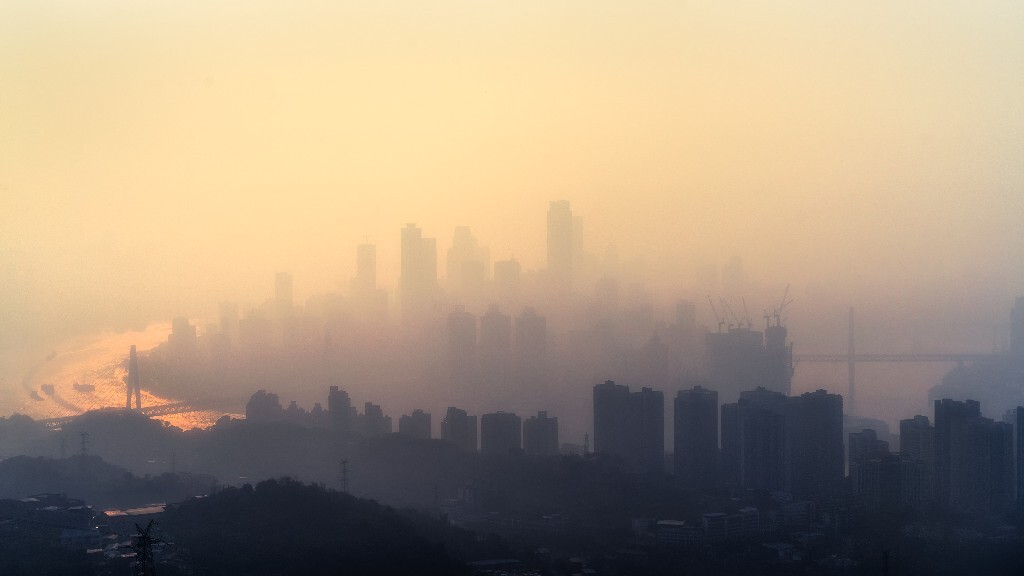 2017年1月22日，下午4点42分，重庆主城区，PM 2.5 160，夕阳下，整个城市笼罩在一层金色雾霾之中。