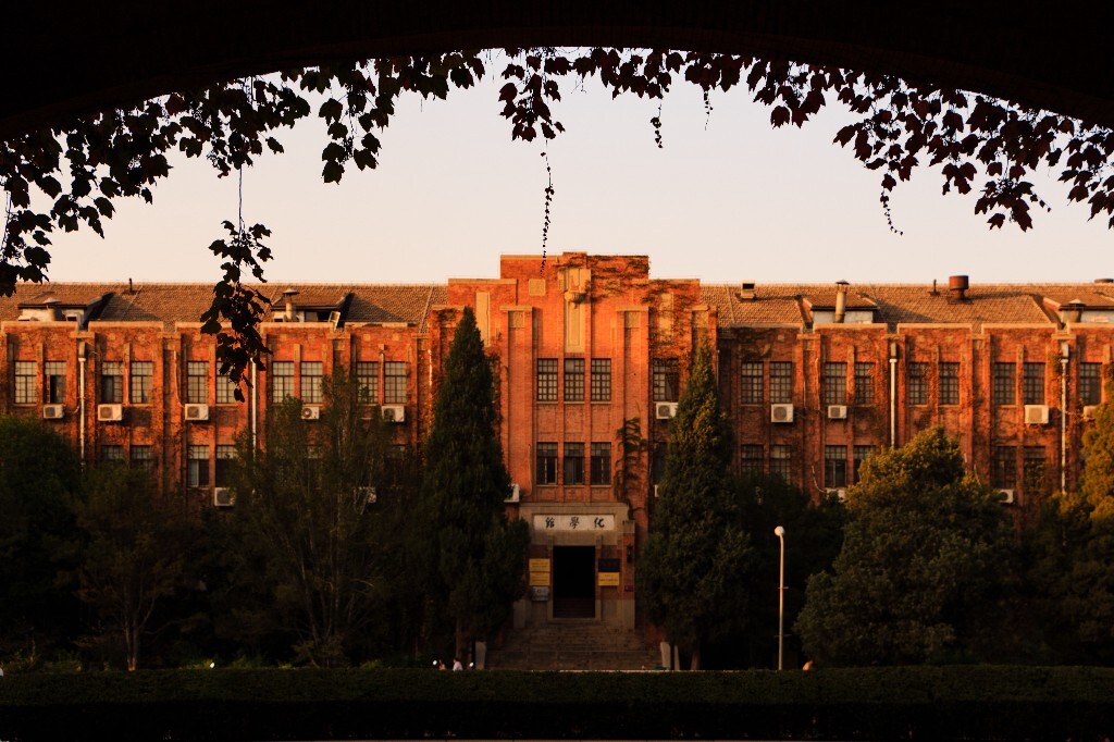 化学馆,在理科楼门洞下远摄。秋天的夕阳照亮了化学老馆,理科楼上的爬山虎压暗变成了剪影。