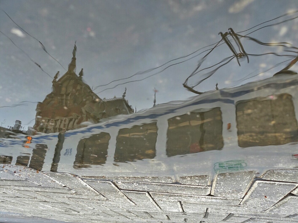 阿姆斯特丹火车站，路过的有轨电车，地面。路面积水的倒影。