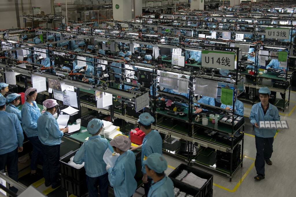 6.	2014年12月9日，广东省东莞市。手机厂的生产车间。