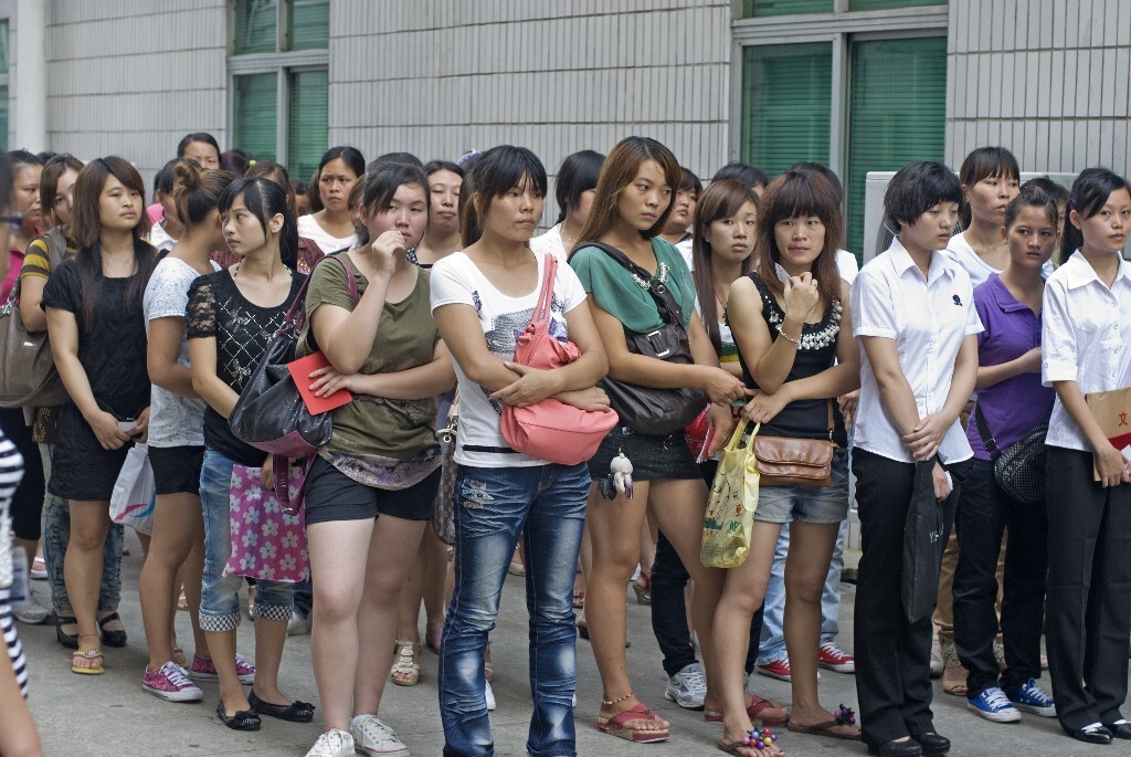 14.	2011年8月2日，广东省东莞市。求职的打工者正在等候面试。