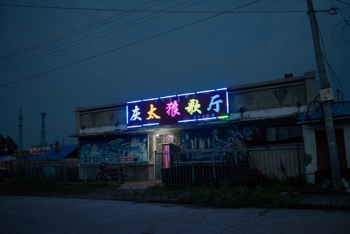 2018年7月23日内蒙古牙克石市图里河镇,夜幕之下营业的歌厅泛着点光亮,大兴安岭禁止伐木后,因林而兴的小镇开始衰退。