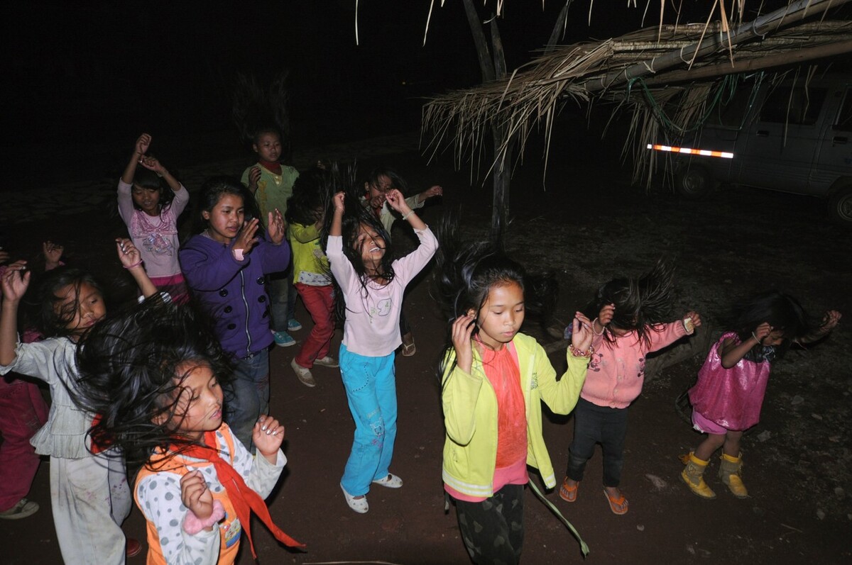 2010年4月2日云南沧源县勐角乡翁丁村,晚上村里的小女孩在《阿佤人民唱新歌》伴奏下练习“甩发舞”。