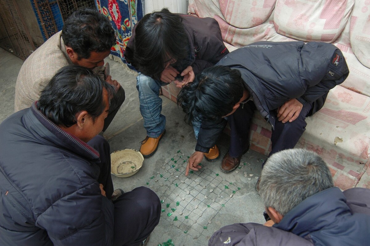 2009年3月31日青海达日县吉迈镇,当地藏族用碎玻璃、小石子就地下棋。