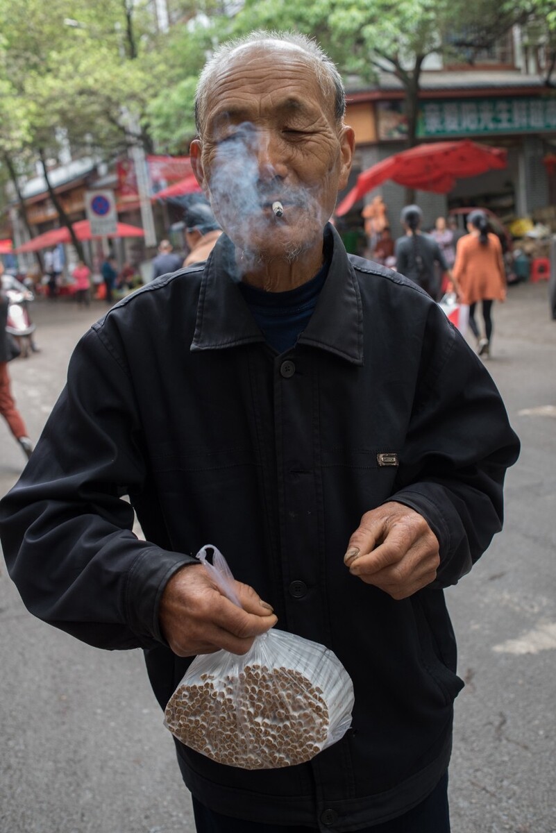 2019年4月23日湖南麻阳县老人买了一袋私家自制的卷烟并点上一支,自制的卷烟论斤卖,10元一斤。