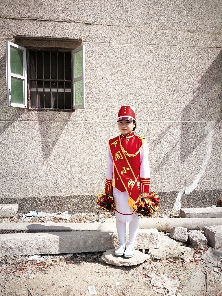 一名参加游神队伍的女孩，她所在的小学由老师组织了一个庞大的仪仗队走在了队伍的最前列（正月十一，潮州市潮安区阁洲二村）