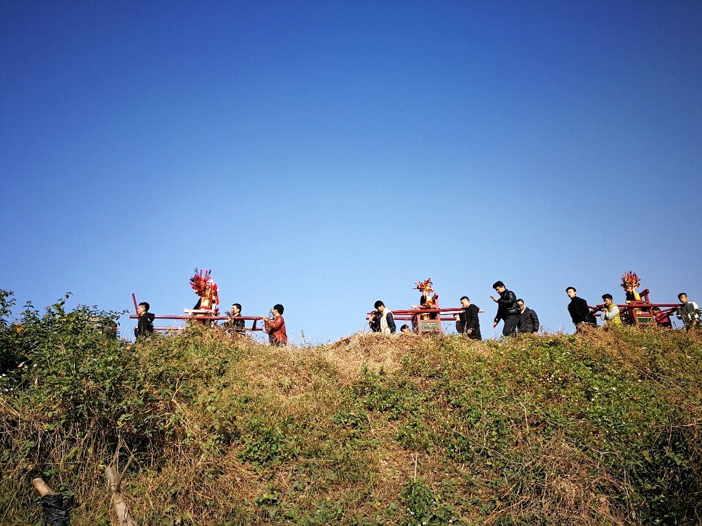 一对营老爷的队伍抬着神像从堤上走过。（正月十七窑美村周厝）