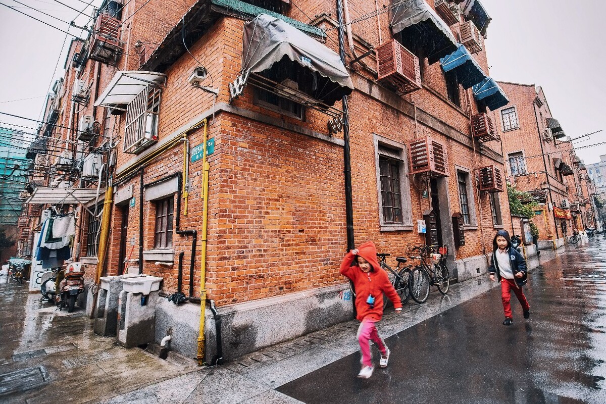 2016年4月2日，上海，绵绵的细雨中，孩子们在弄堂里欢乐追逐嬉戏。