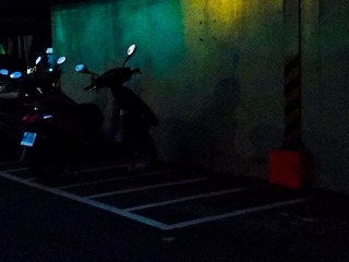18.12.24-4，出去买卡纸的路上，看见这个电动车的影子很像一个人形，挺有趣的，在拍下来的时候正好是绿灯，光的散射在按下快门的同时在墙上打出了绿色
