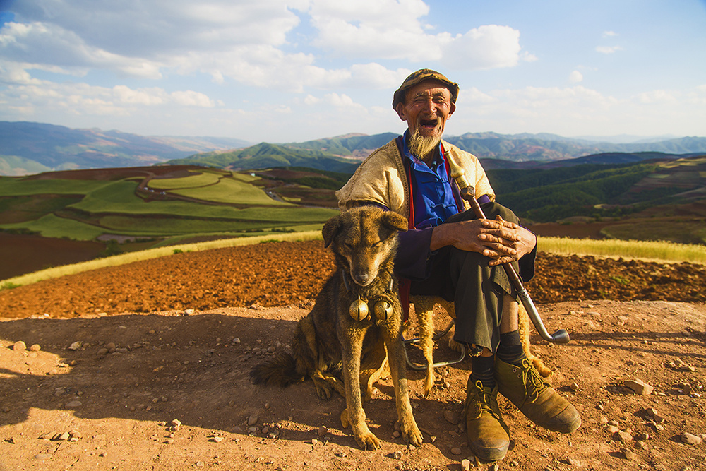 云南东川红土地幸福的牧羊老人.