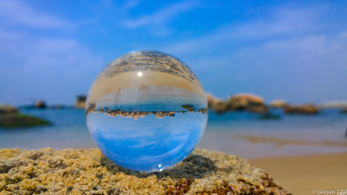 带着水晶球在海边拍照