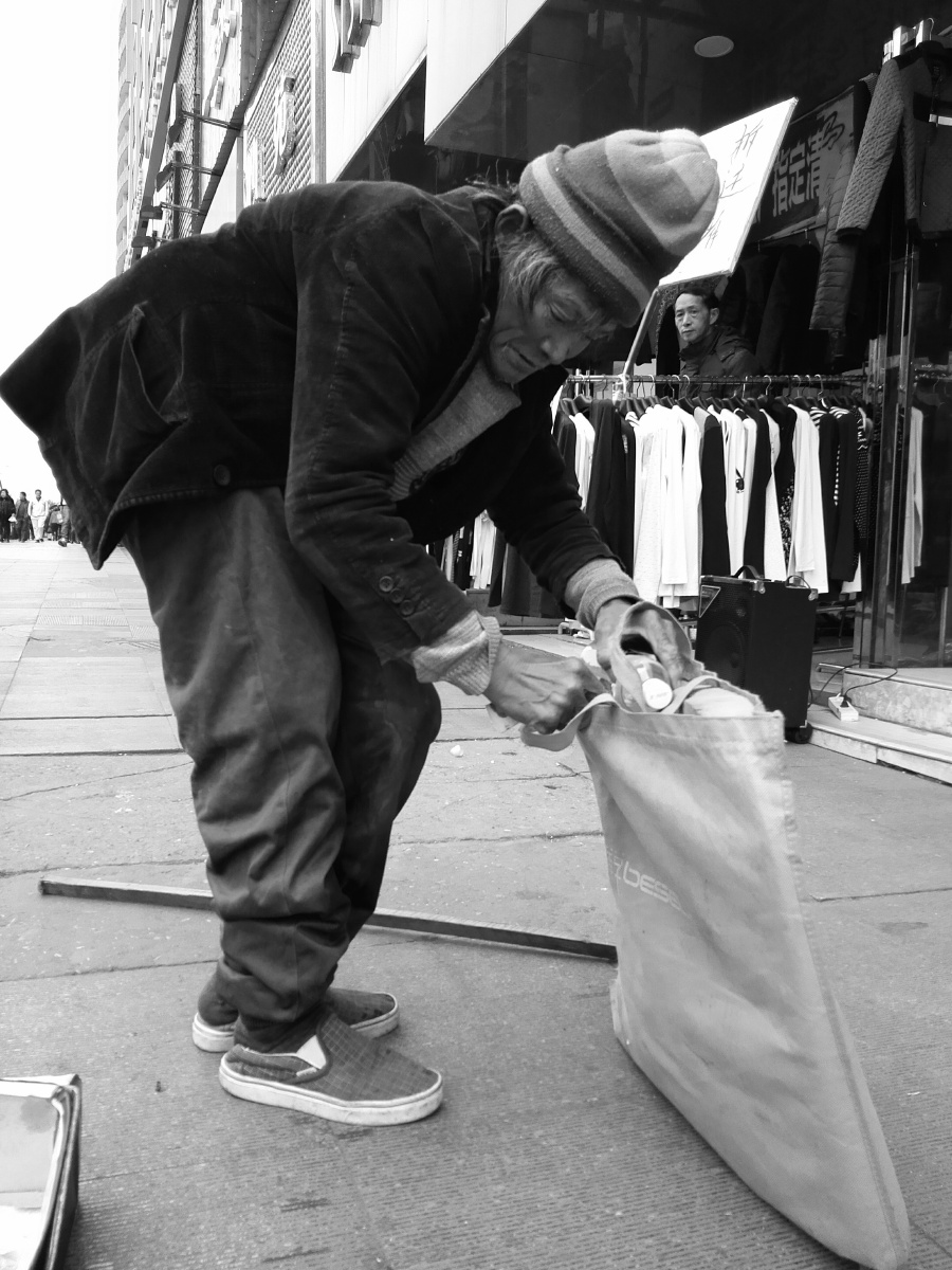 老人家把捡来的饮料瓶放进袋子里