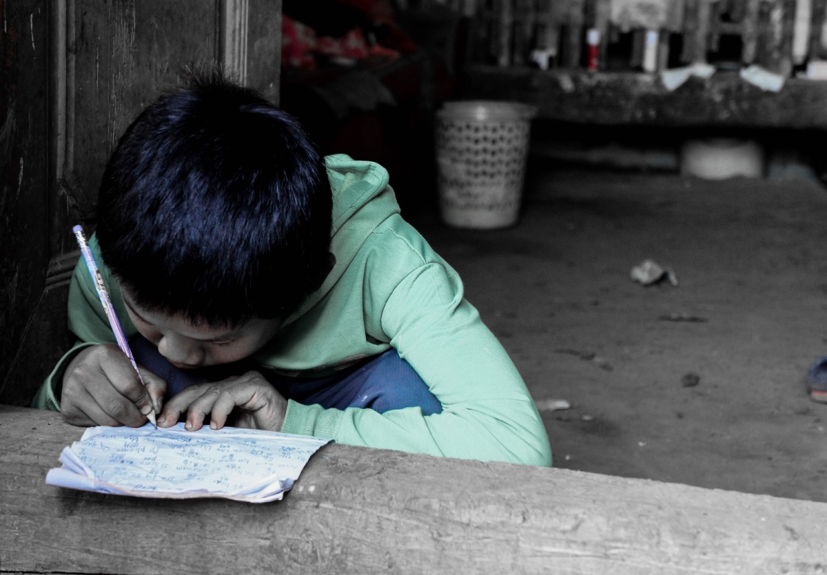 照片于2015年冬拍于云南腾冲山区,小男孩家里没有课桌,家里没电,下课