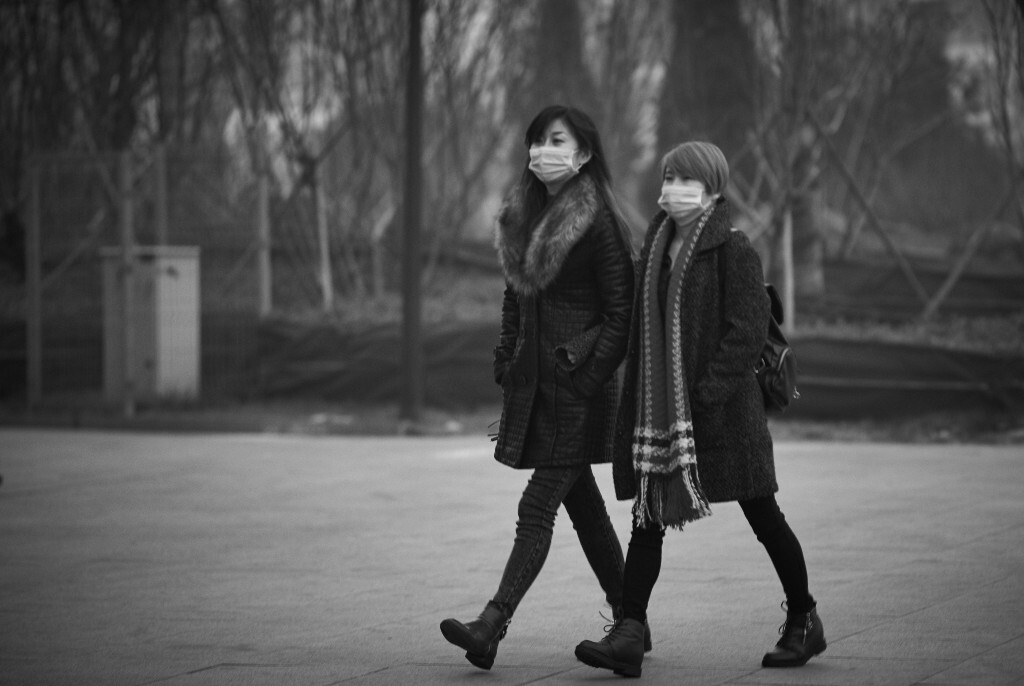 #滚蛋雾霾君# 商场门前，两位穿着时尚的美女戴着口罩走过，因为雾霾，美丽的面容不得不躲在口罩后面。