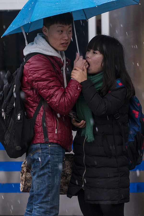 主城迎来20年一遇的大雪,一对情侣在雪中哈手取暖