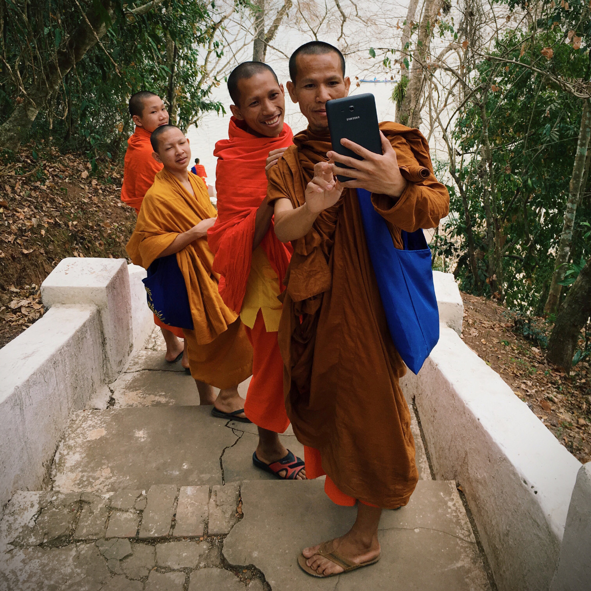 老挝琅勃拉邦的千佛洞,几位南传佛教的僧人轻松一刻.