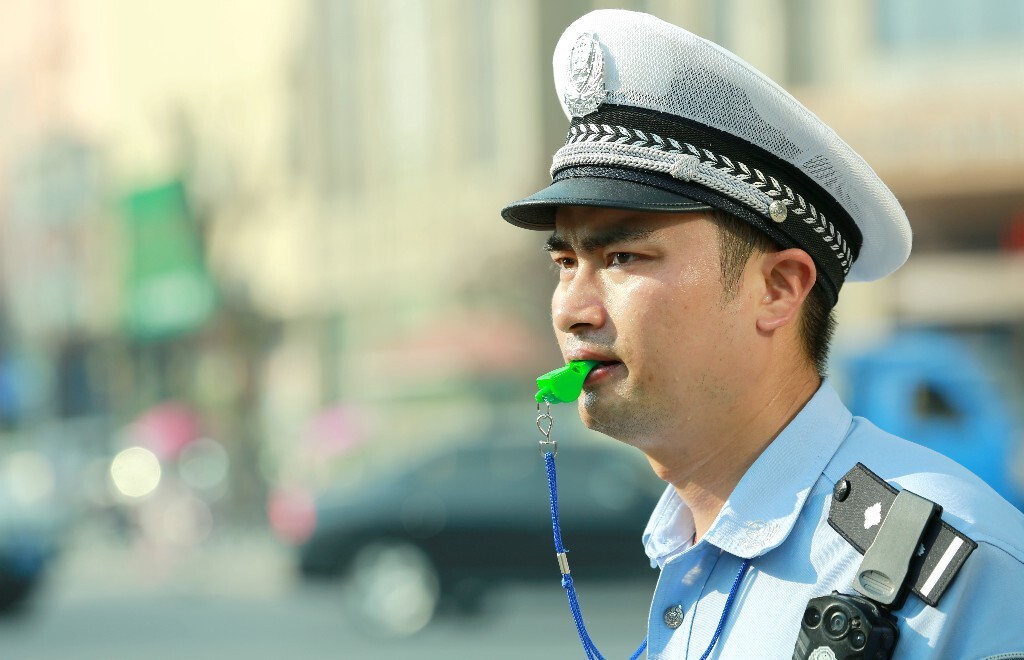 大盖帽下是一张俊朗的脸。他快速环顾左右,目光坚毅犀利,手势果断有力,转身、落步,干脆利落。这个路口,胡义兵站了5年。
